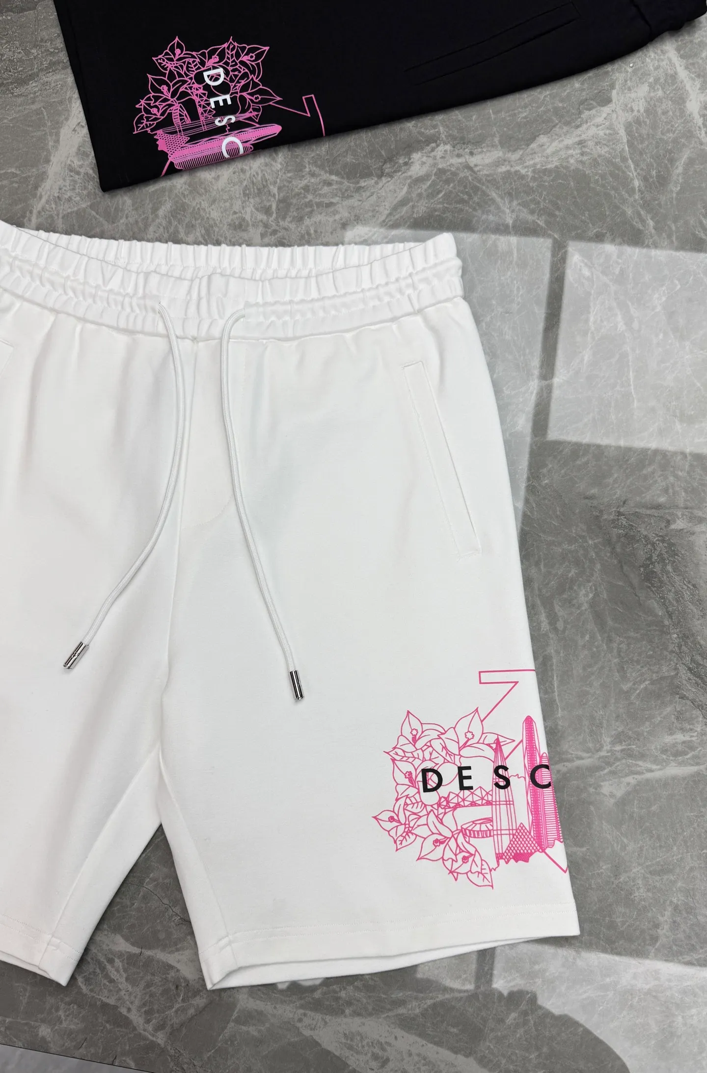 Tops 175. Pants 190 ⚜️DESCENT*Desante New Arrival trendy brand five-point shorts. Same Style for men and women❤️can be paired with T-shirts as a complete set👍🏻Recommended solid colors! Sideways seamless design. Classic letter graphic logo. 3D heat transfer design. Simple and advanced. Excellent texture, comfortable and breathable. Unforgettable! Customized high-quality high-density nylon and cotton fabric. Crisp and stylish. Comfortable and soft. All three standards! Color: Black.White.Sizes: M-3XL/29-36 (S and 4xl can be customized) 175/140 catties recommended L