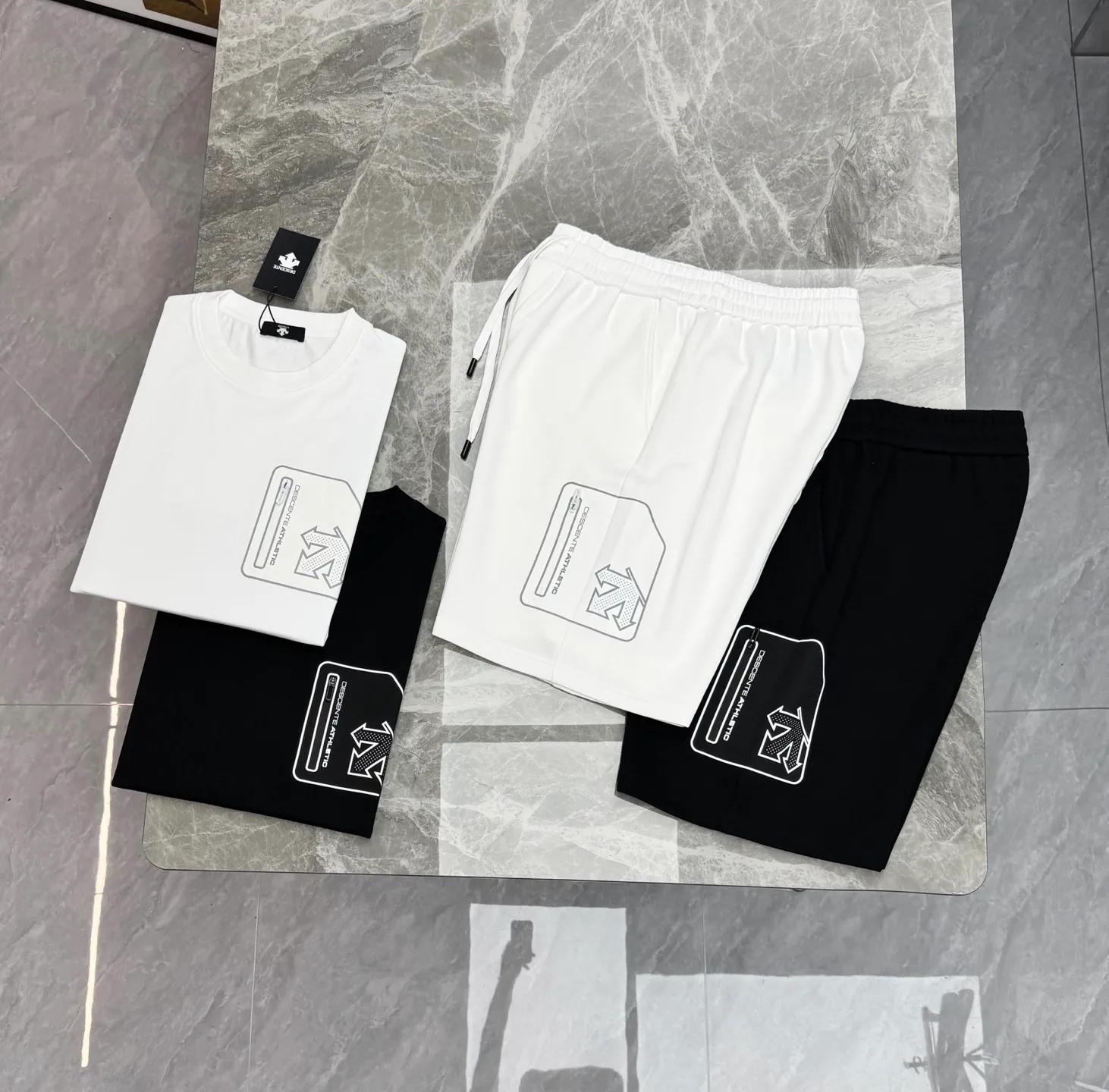 A set of ⚜️Descente New Arrival summer suit. Same Style for men and women❤️Solid color. Pocket design. Brand graphic pockets on the chest and outer thighs. Zippered patch pockets are convenient for storing small items, improving practicality. The patch pockets are printed with brand logos for perfect recognition. The pure cotton material is soft and comfortable. Commonly found in sports T-shirts, jackets, etc., it is both functional and fashionable, and is suitable for daily sports or outdoor! Color: Black.White.Sizes: M-3XL (L is recommended for 175/140 pounds)
