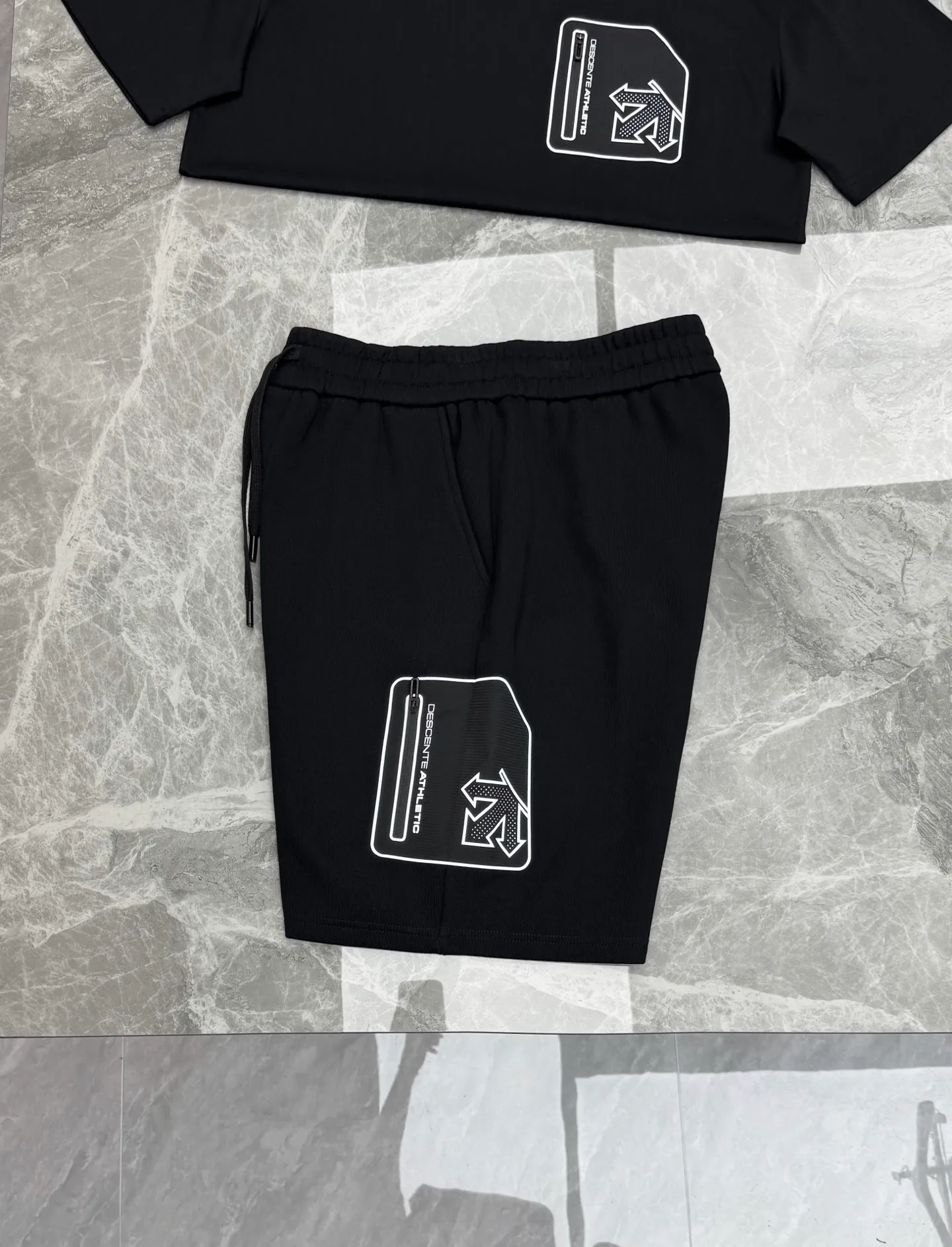A set of ⚜️Descente New Arrival summer suit. Same Style for men and women❤️Solid color. Pocket design. Brand graphic pockets on the chest and outer thighs. Zippered patch pockets are convenient for storing small items, improving practicality. The patch pockets are printed with brand logos for perfect recognition. The pure cotton material is soft and comfortable. Commonly found in sports T-shirts, jackets, etc., it is both functional and fashionable, and is suitable for daily sports or outdoor! Color: Black.White.Sizes: M-3XL (L is recommended for 175/140 pounds)